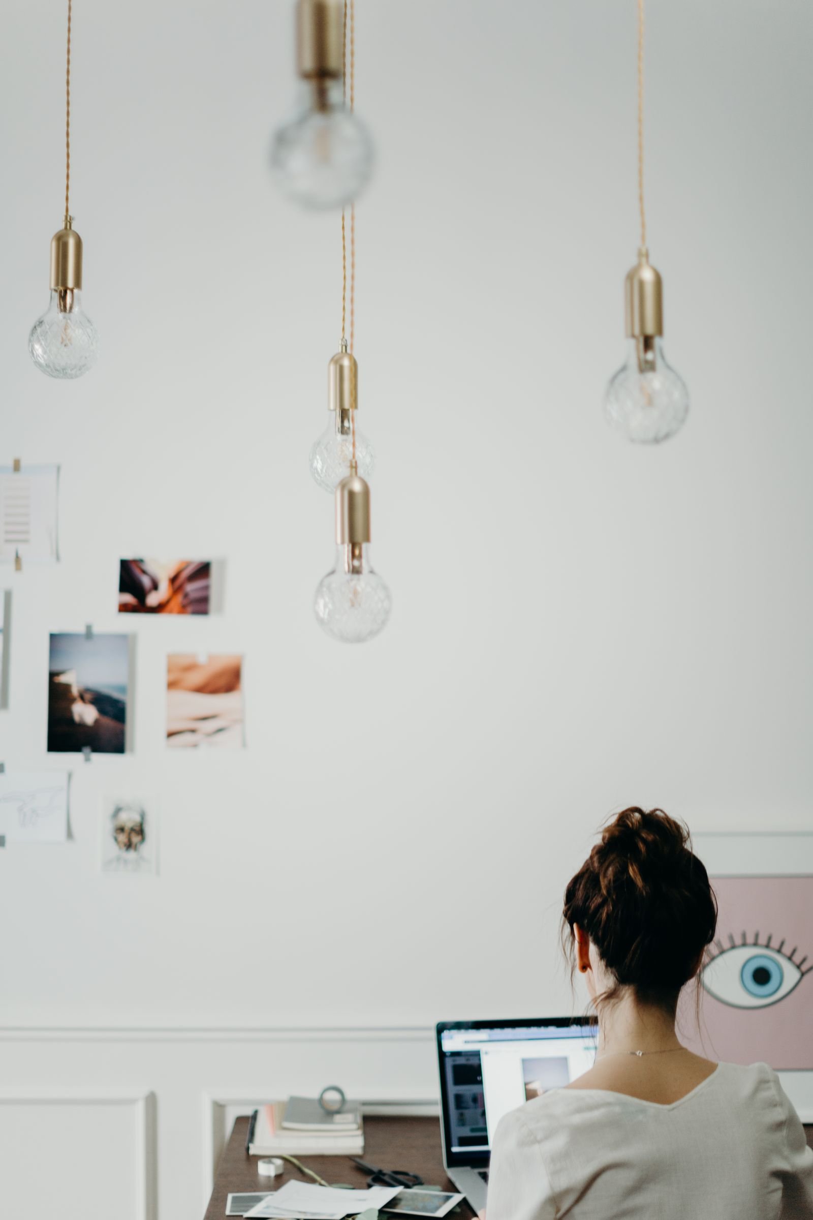 Mujer trabajando en su escritorio en una oficina creativa con tableros de inspiración