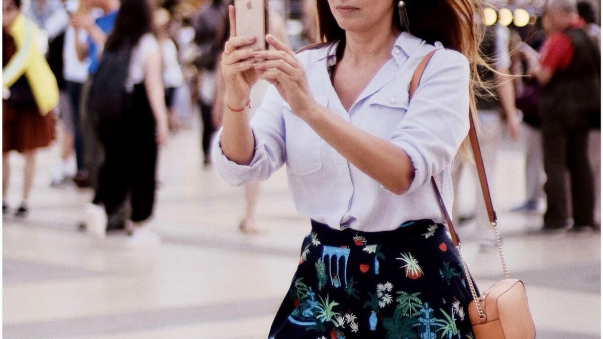 Mujer tomando una foto con su celular en la calle